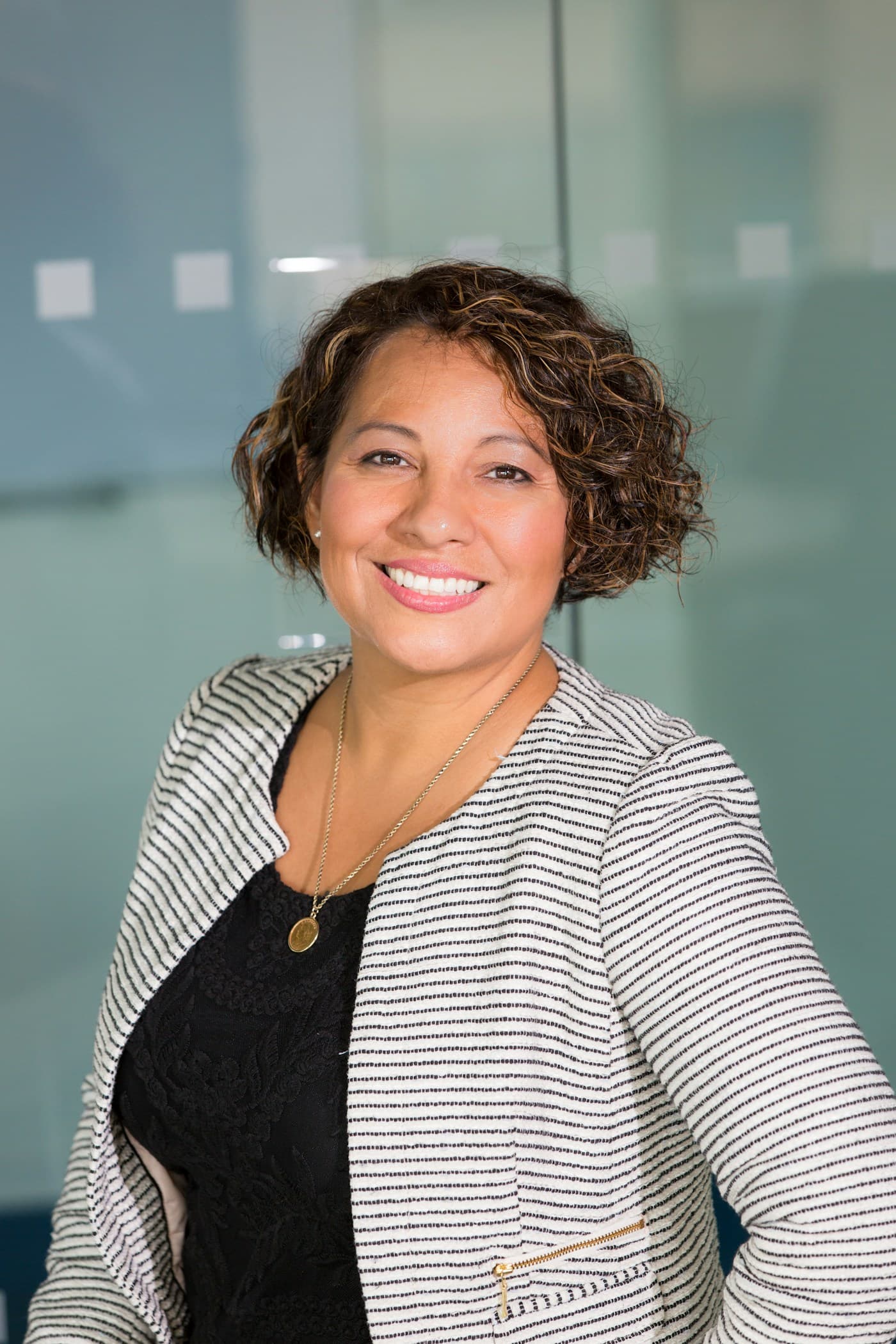 Senior operator with curly hair, striped blazer, modern office