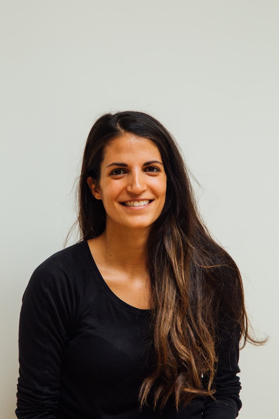 Senior operator with long hair, black top, neutral background